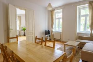 Central Living Apartments - Schönbrunn في فيينا: غرفة معيشة مع طاولة وأريكة