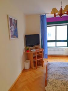 a room with a television and a desk with a computer at Habitación Doble Particular in A Coruña