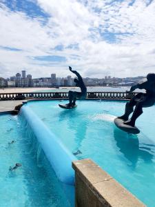 a statue of two surfers in a pool of water at Habitación Doble Particular in A Coruña