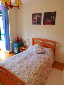 a bedroom with a bed and two pictures on the wall at Habitación Doble Particular in A Coruña