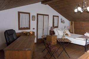 a bedroom with a bed and a desk and a table at Arxontiko Palamas in Palamás