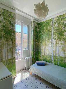 瓦倫西亞的住宿－Vlc Center 4 Room Apartment，一间卧室设有一张床和一个树木繁茂的窗户