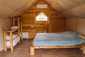 a bedroom in a tent with a bed and a window at Гора Глэмпинг in Besqaynar