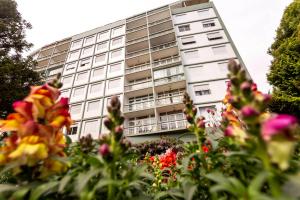 a tall building with flowers in front of it at Incrível Vista no Capivari com 4 Quartos e Lareira in Campos do Jordão