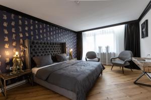 a bedroom with a large bed and a desk and chairs at Waldhotel Luise in Freudenstadt