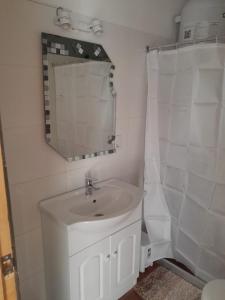 a white bathroom with a sink and a mirror at Apartamento en Colonia in Colonia del Sacramento