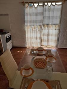 科洛尼亞－德爾薩克拉門托的住宿－Apartamento en Colonia，一张桌子、两把椅子和一张桌子,上面有盘子