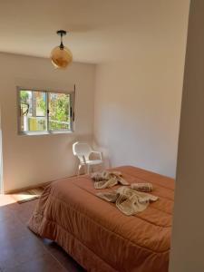 1 dormitorio con 1 cama, 1 silla y 1 ventana en Apartamento en Colonia, en Colonia del Sacramento