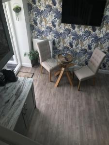 a living room with two chairs and a table at Traeth Arian Cottage in Benllech