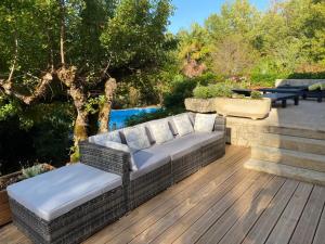 een patio met een bank en stoelen op een houten terras bij Maison de 2 chambres avec piscine privee jardin amenage et wifi a Bruniquel in Bruniquel