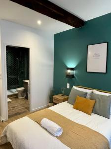 ein Schlafzimmer mit einem großen Bett und einer grünen Wand in der Unterkunft L'Odyssée in Saint-Étienne