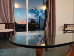 藻德济2 0 HÔTEL Vanille的客厅里设有玻璃桌,配有窗户