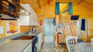 a kitchen with a staircase in a tiny house at Seiriol at Llanfair Hall in Dwyran