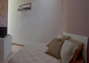 una camera con letto, cuscini e TV di Dimora nel borgo a Offida
