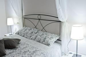 una camera bianca con un letto con testiera nera di Dimora nel borgo a Offida