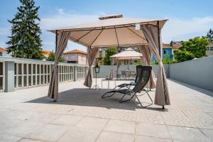 einen Pavillon mit einem Stuhl und einem Sonnenschirm auf einer Terrasse in der Unterkunft Oporto Guest House Terrace in Porto