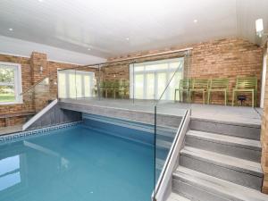 a swimming pool with blue water in a building at Hall Farm in Market Rasen