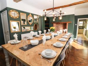 a long wooden table with chairs and plates on it at Hall Farm in Market Rasen