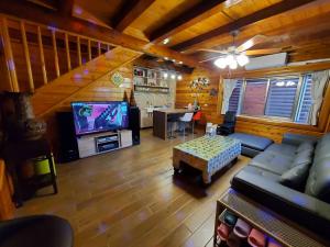 a living room with a couch and a tv at 秋憶木屋 in Gukeng