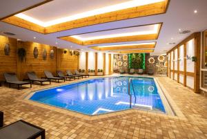 - une piscine dans une chambre d'hôtel dotée de tables et de chaises dans l'établissement Waldhotel Luise, à Freudenstadt