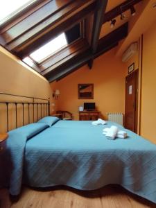 sypialnia z dużym niebieskim łóżkiem i świetlikiem w obiekcie Hotel Balcon de Aguera w mieście San Martín