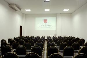 an empty lecture room with chairs and a screen at Líber Hotel Nova Serrana - Conforto na Rota da BR-262 in Nova Serrana