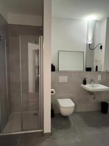 a bathroom with a shower and a toilet and a sink at Apartmenthaus Sassnitz Zum Stadthafen Apartment 5 in Sassnitz