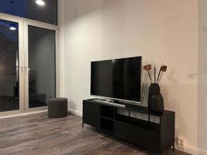 a living room with a flat screen tv on a black entertainment center at Apartmenthaus Sassnitz Zum Stadthafen Apartment 5 in Sassnitz