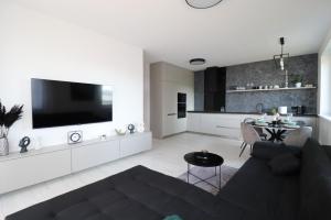 a living room with a couch and a tv on a wall at MBV28 Apartments in Poprad