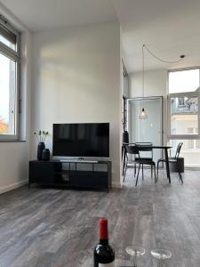 ein Wohnzimmer mit einem TV und einem Tisch mit Stühlen in der Unterkunft Apartmenthaus Sassnitz Zum Stadthafen Apartment 2 in Sassnitz