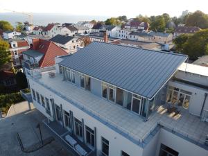 eine Luftansicht eines Hauses mit blauem Dach in der Unterkunft Apartmenthaus Sassnitz Zum Stadthafen Apartment 2 in Sassnitz