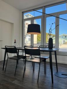 ein Esszimmer mit einem Tisch, Stühlen und einer Lampe in der Unterkunft Apartmenthaus Sassnitz Zum Stadthafen Apartment 10 in Sassnitz