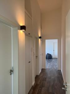 einen leeren Flur mit weißen Wänden und Holzböden in der Unterkunft Apartmenthaus Sassnitz Zum Stadthafen Apartment 10 in Sassnitz