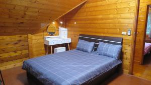 a bedroom with a blue bed and a wooden wall at 秋憶木屋 in Gukeng