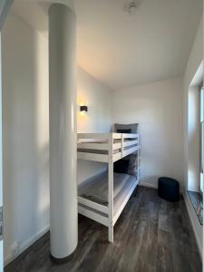 Zimmer mit einem weißen Schreibtisch und einer Säule in der Unterkunft Apartmenthaus Sassnitz Zum Stadthafen Apartment 10 in Sassnitz
