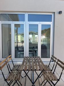 eine Holzbank auf einer Veranda neben den Fenstern in der Unterkunft Apartmenthaus Sassnitz Zum Stadthafen Apartment 10 in Sassnitz