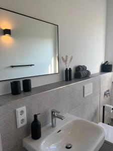 ein Bad mit einem Waschbecken und einem Spiegel in der Unterkunft Apartmenthaus Sassnitz Zum Stadthafen Apartment 10 in Sassnitz