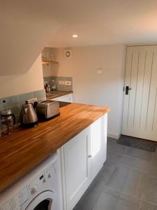 a kitchen with a wooden counter top with a washing machine at The Studio in Ashton Keynes