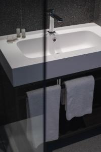 - Baño con lavabo blanco y toallas en Hub Hotel en Gubbio