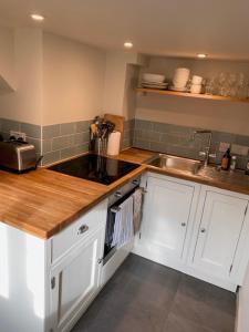 a kitchen with white cabinets and a sink at The Studio in Ashton Keynes