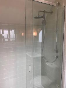 a shower with a glass door in a bathroom at The Studio in Ashton Keynes