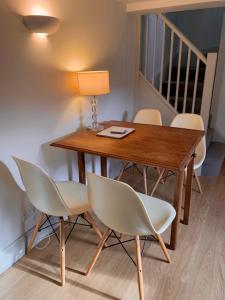 a wooden table with four chairs and a lamp on it at The Studio in Ashton Keynes