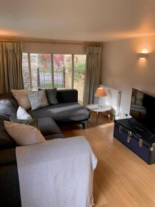 a living room with a couch and a tv at The Studio in Ashton Keynes