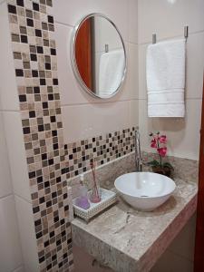 a bathroom with a sink and a mirror at Refúgio BEM-TE-VI in Guarujá