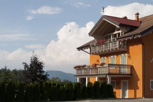 a building with a balcony with flowers on it at Agritur Agribaldo Lavanda in Brentonico