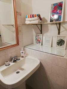 ein Badezimmer mit einem Waschbecken, einem Spiegel und Handtüchern in der Unterkunft Av Roque Saenz Peña 1440 Tercer Piso D in Posadas