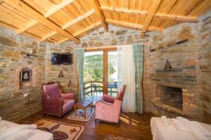a room with two chairs and a stone fireplace at Heaven's Gate in Sirince