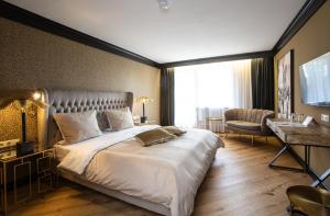 Habitación de hotel con cama grande y escritorio. en Waldhotel Luise en Freudenstadt