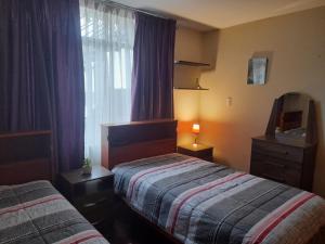 - une chambre avec 2 lits et une fenêtre dans l'établissement Casa Navarra, à Lima