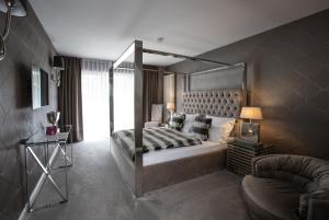 Waldhotel Luise في فرودنستاد: غرفة نوم مع سرير مظلة وأريكة